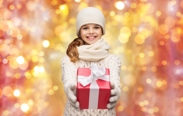 happy girl in hat, scarf and gloves with gift box - Photo, Image