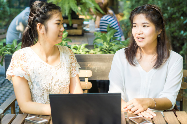 Negócios mulheres asiáticas discutindo plano de negócios no laptop no café
  - Foto, Imagem