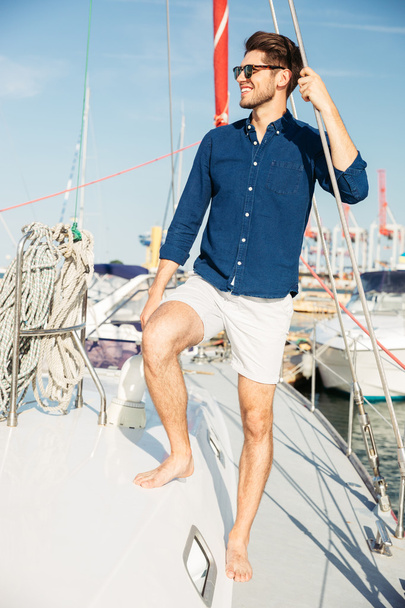 Young stylish sailor man standing on the yacht - Foto, imagen