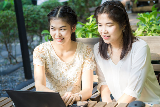 Negocios mujeres asiáticas discutiendo plan de negocios en el ordenador portátil en la cafetería
  - Foto, imagen