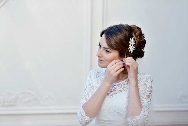 Beautiful bride puts on earring - Photo, Image