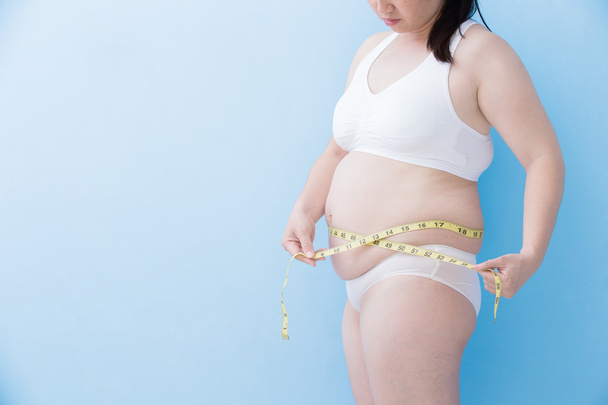 woman measuring  waist with tape - Foto, imagen