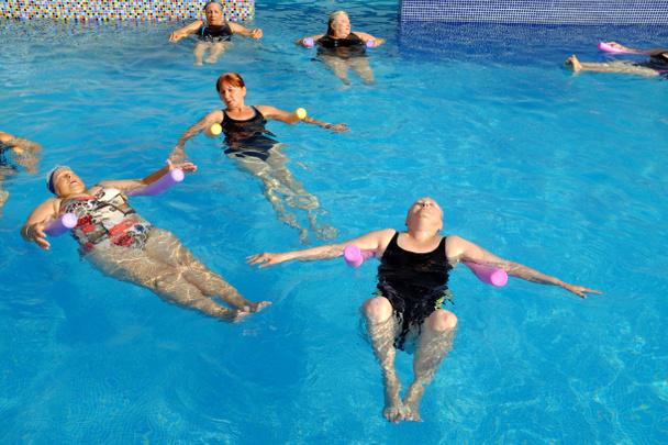 プールで運動をしている年配の女性のグループ. - 写真・画像