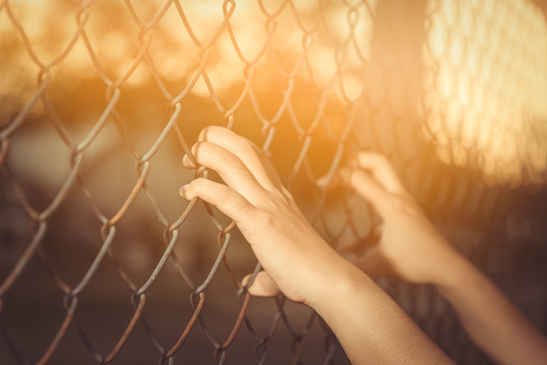 Hand holding on chain link fence  - Zdjęcie, obraz
