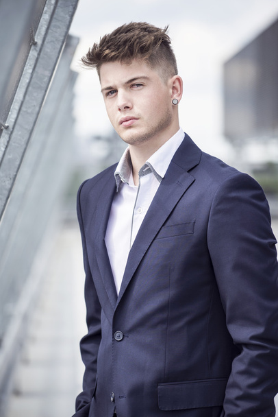 Young handsome man in a blue suit against the city - Fotografie, Obrázek