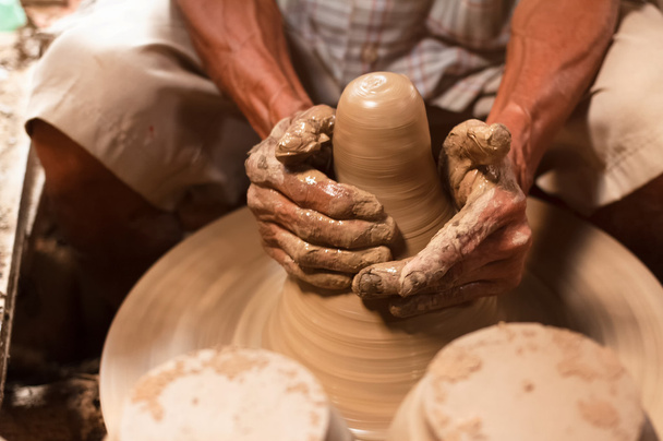 陶器のホイールに粘土で作る陶工の手. - 写真・画像