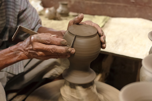 Potter hands making in clay on pottery wheel. - Фото, изображение