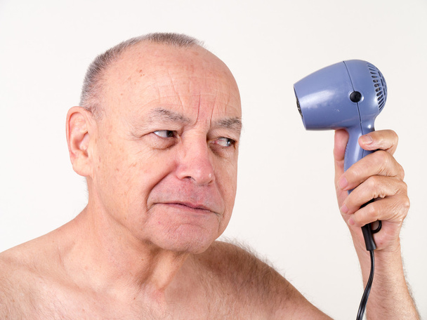 ein glatzköpfiger Mann mit einem Föhn - Foto, Bild