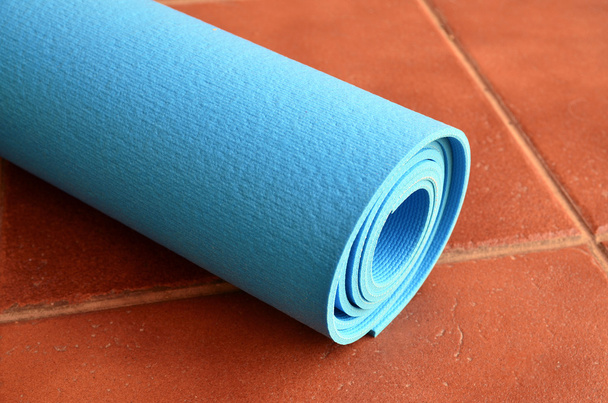 blaue Yogamatte für das Training zu Hause oder im Fitnessstudio. - Foto, Bild