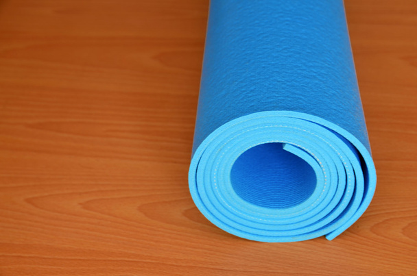 Blue yoga mat for exercise at home or gym. - Foto, imagen