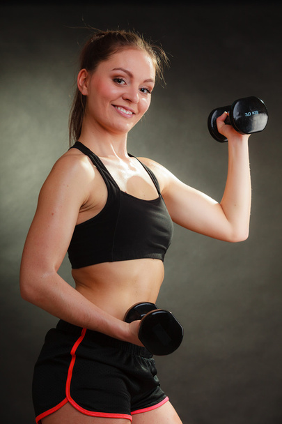 Fit woman exercising with dumbbells. - Fotó, kép