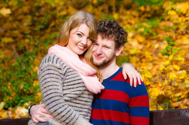 Lovers couple in autumn park on bench - Φωτογραφία, εικόνα