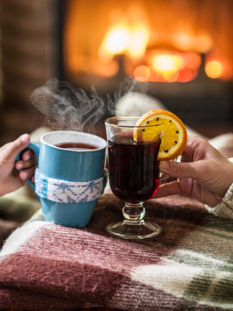 Warming and relaxing near fireplace with a cup of hot drink. - Foto, Bild