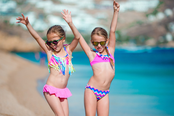Чарівні маленькі дівчата розважаються під час пляжних канікул
 - Фото, зображення