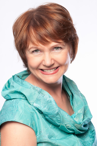 Beautiful fashionable smiling mature woman in turquoise costume - Фото, изображение