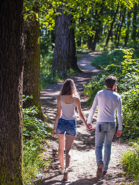 young couple walking in forest - 写真・画像