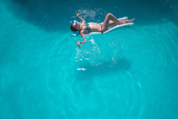 Young woman relaxing in pool - Фото, зображення