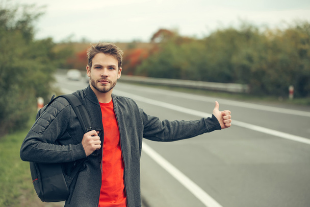 Young man hitchhiking - Foto, afbeelding