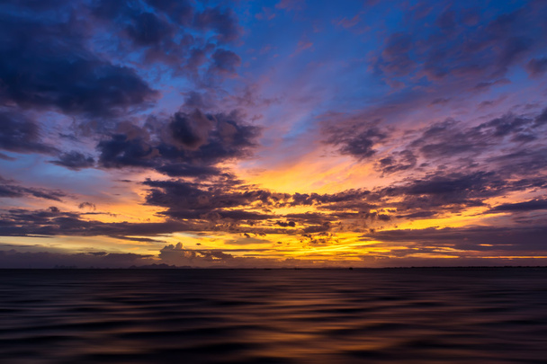 Прекрасний захід сонця в озері з насиченим небом і хмарами
. - Фото, зображення