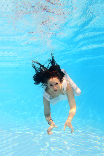 Woman wearing a white dress underwater - 写真・画像