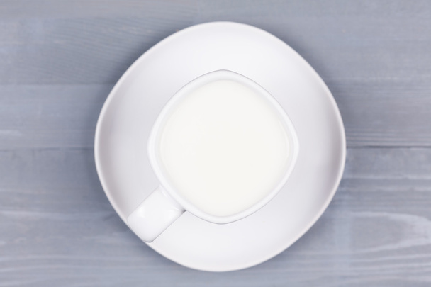 Top view of a white cup of milk on wood. - Фото, изображение