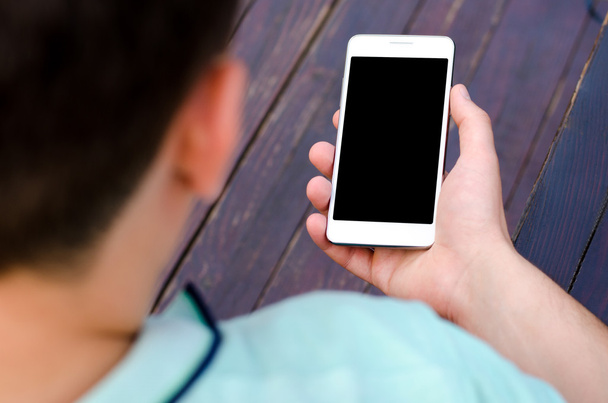 Білий мобільний телефон тримає молодого хіпстера в бізнесі на фіолетовому дерев'яному фоні
 - Фото, зображення