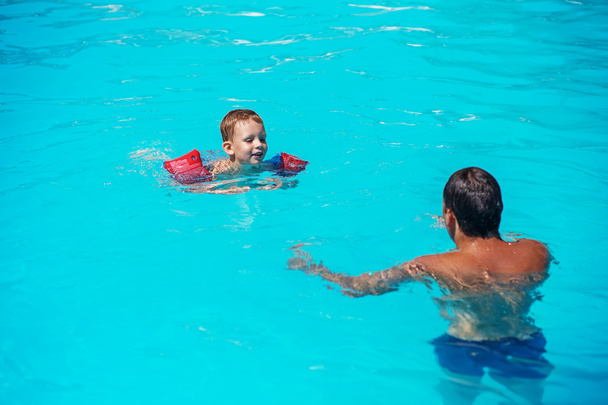 Tata i syn bawią się w basenie pływmming - Zdjęcie, obraz
