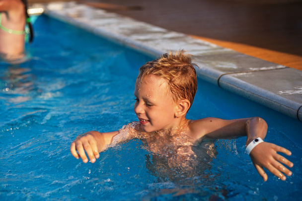 Enfant heureux jouant dans l'eau bleue de la piscine
. - Photo, image