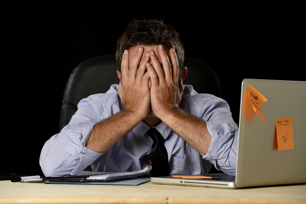 κουρασμένος επιχειρηματίας υποφέρει δουλειά άγχος σπαταλιέται ανησυχούν απασχολημένος στο γραφείο αργά το βράδυ με φορητό υπολογιστή - Φωτογραφία, εικόνα