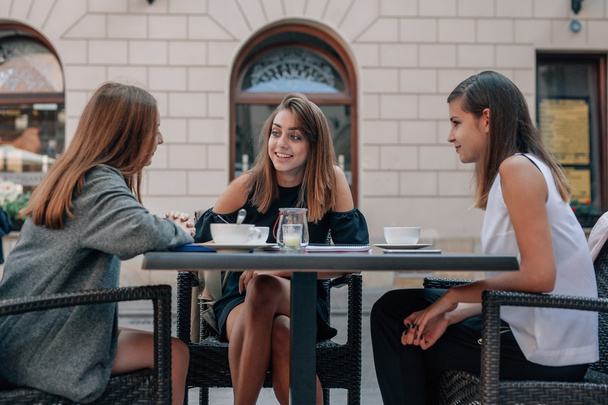 Three young women are talking at the cafe restaurant. Outdoor ba - Foto, Imagen