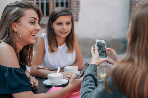 若い女性が座って、携帯電話を使用しています。屋外カフェ bac - 写真・画像