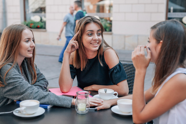 Young  women are talking at the cafe restaurant. Outdoor backgro - Foto, afbeelding