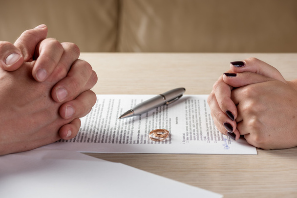 Wife and husband signing divorce documents or premarital agreement - Foto, Imagen