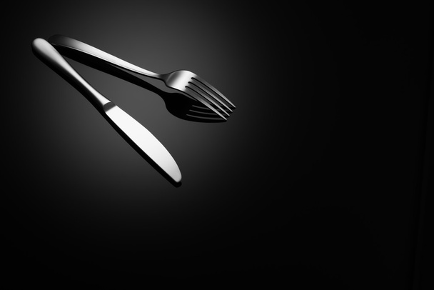 Black food background with knife and fork - Photo, Image
