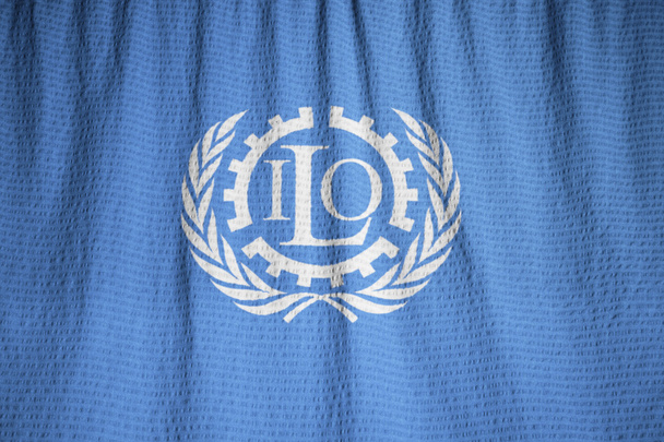 Primer plano de la bandera de la Organización Internacional del Trabajo con volantes
 - Foto, Imagen