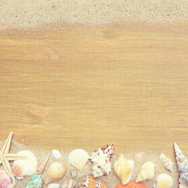Seashells and starfish on a old wooden background. Photo in vintage style - Фото, изображение