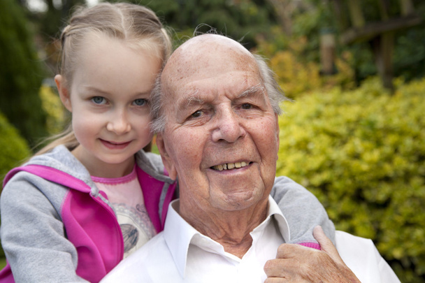 95 jaar oud Engels man met kleindochter in tuin - Foto, afbeelding
