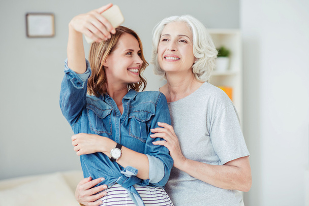 Positive delighted woman and her mother making selfies - Foto, immagini