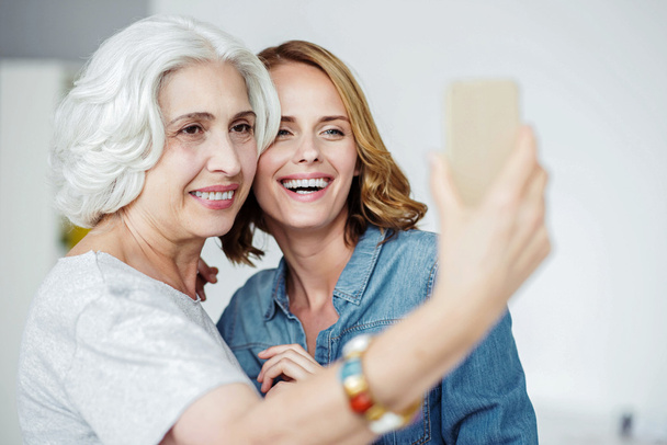 Joyful senior woman making selfies wit her granddaughter - Photo, Image