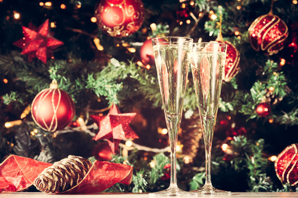 Δύο ποτήρια σαμπάνιας με φόντο χριστουγεννιάτικο δέντρο. Ενοικιαζόμενα - Φωτογραφία, εικόνα