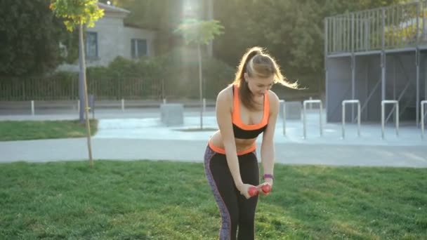 Young girl doing active exercises with weights outdoor in 4K - Footage, Video