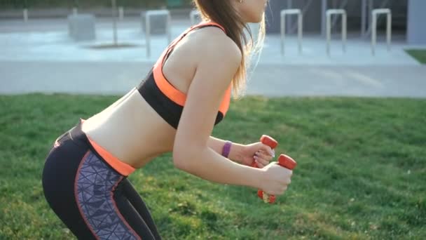 Young girl doing morning exercises with weights outdoor in 4K - Filmmaterial, Video