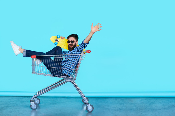 young man in shopping cart - Zdjęcie, obraz