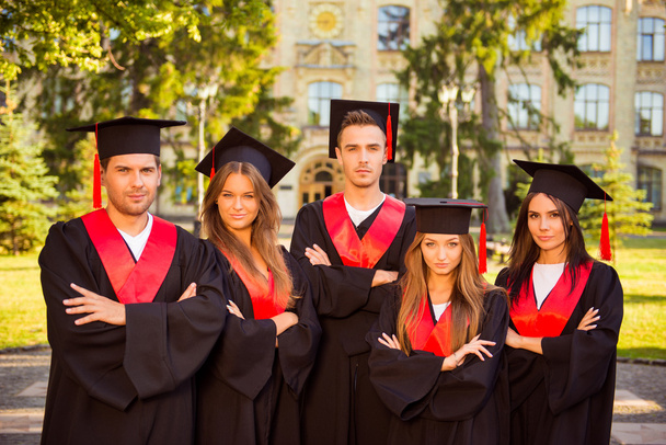 successful confident five graduates in robes and hats standing i - Фото, изображение