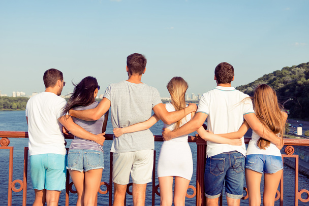 em férias de verão grupo de estudantes amigáveis abraçando na cidade em
 - Foto, Imagem