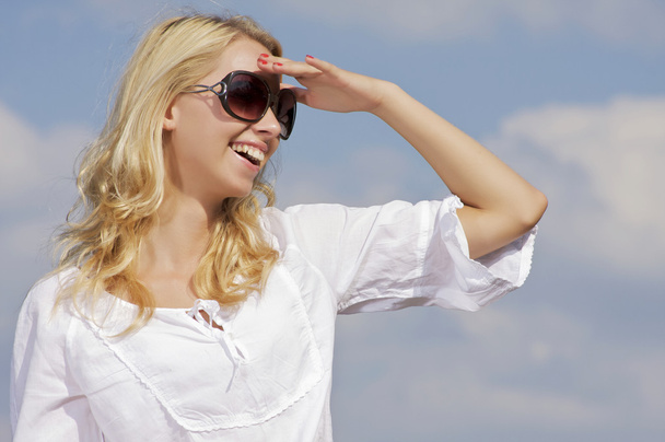 Beautiful girl in sunglasses on background blue sky - Zdjęcie, obraz