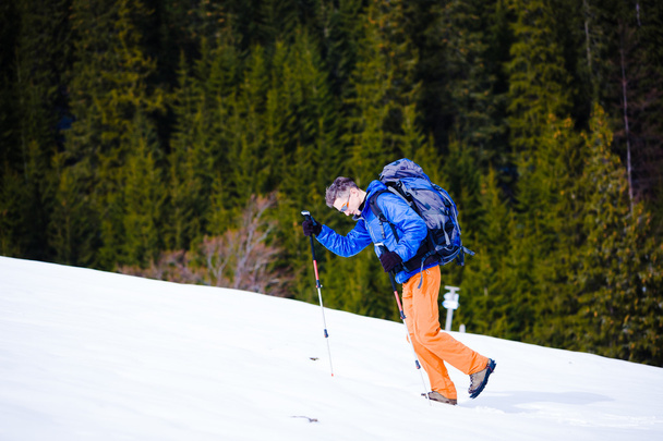 Bergsteiger wandert auf schneebedecktem Hang. - Foto, Bild