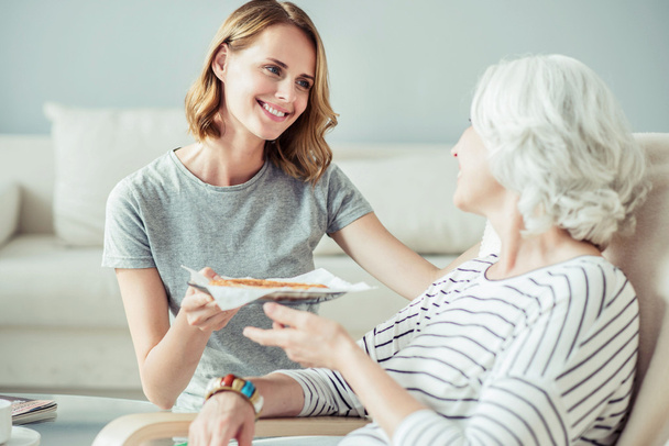 Positive woman giving her mother a tasty pie - Foto, Bild