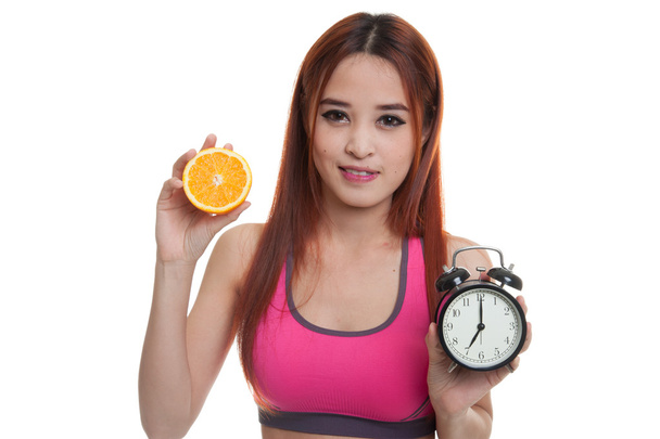Beautiful Asian healthy girl with orange and clock. - Fotoğraf, Görsel