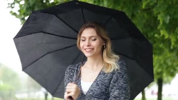 Happy girl with umbrella in hands - Кадры, видео